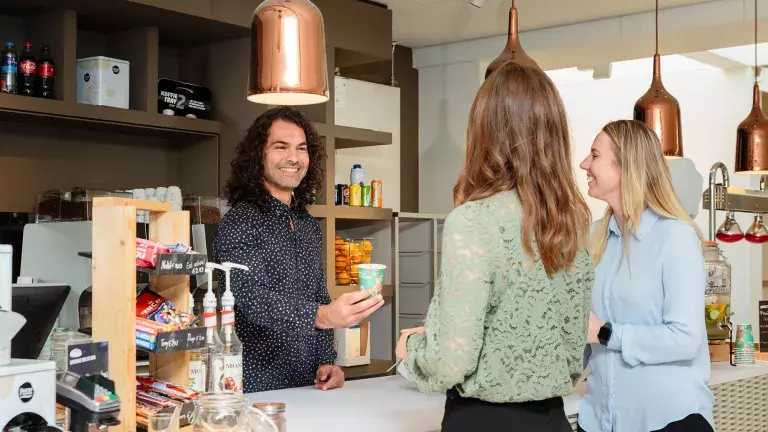 Twee collega's ontvangen een kop koffie in het netwerkcafe