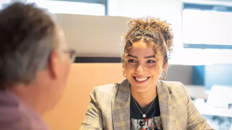 Collega Naoual is in gesprek met een andere collega.